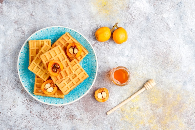 Kostenloses Foto quadratische belgische waffeln mit wollmispelfrüchten und honig.