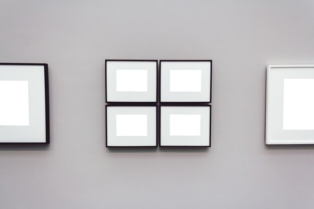 Quadratische weiße leere Rahmen an einer grauen Wand befestigt