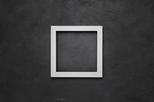 Quadratischer weißer leerer Rahmen auf grauem strukturiertem Hintergrund mit Copyspace