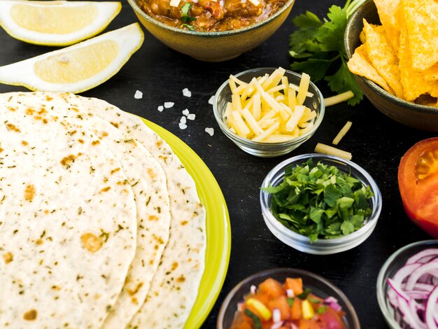 Quesadilla in der Nähe von Tassen mit Gemüse und Kartoffeln