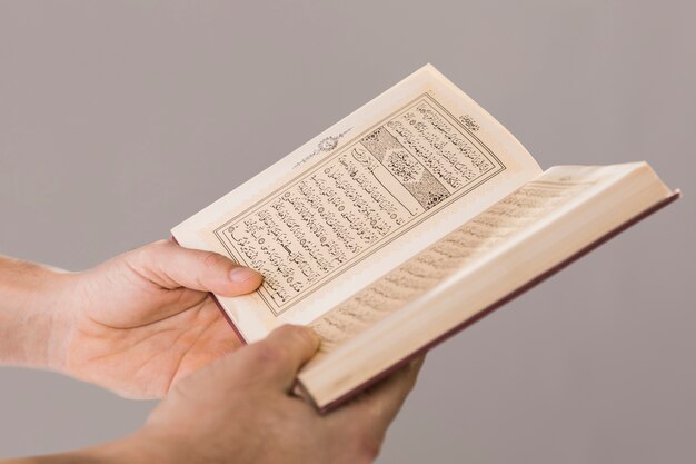 Quran, der in Handnahaufnahme gehalten wird