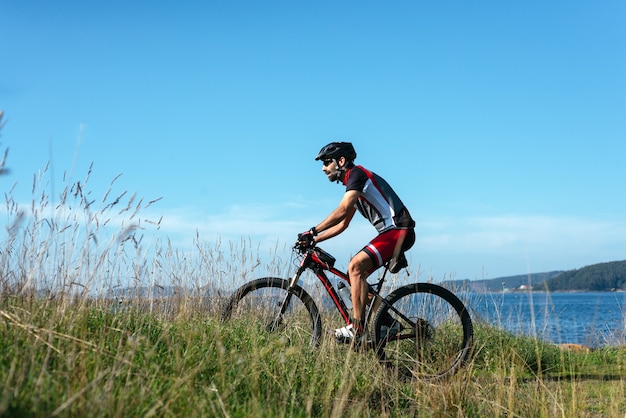 Radfahrer, der sein Fahrrad an der Meeresküste fährt