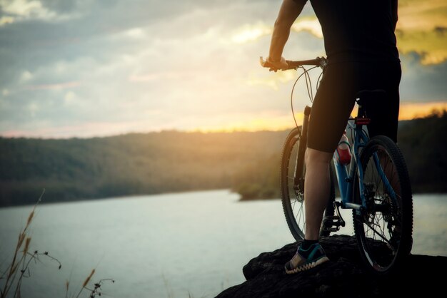 Radfahrer-Mann, der Fahrrad auf Berg läuft