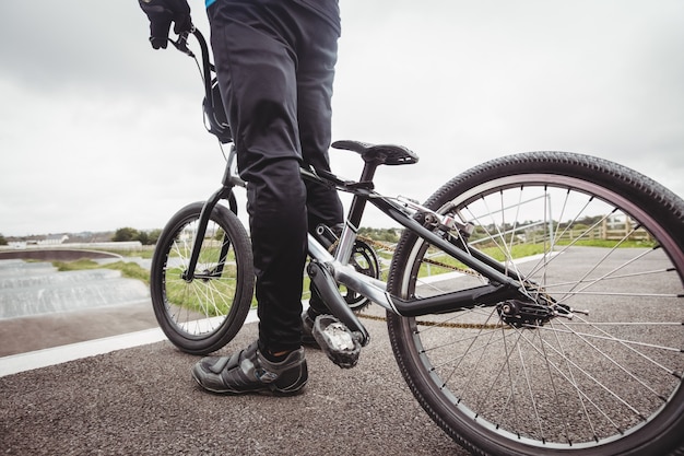 Radfahrer stehend mit BMX-Fahrrad an der Startrampe