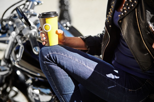 Radfahrermädchen in einer Lederjacke auf einem Motorrad