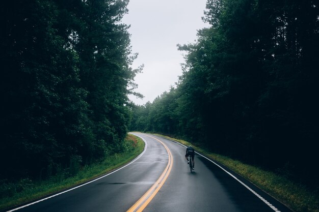 Radfahrermann, der ein Fahrrad auf der Straße reitet