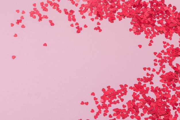 Rahmen aus rotem konfetti in form von herzen rotes konfetti abstraktes muster auf rosa hintergrund
