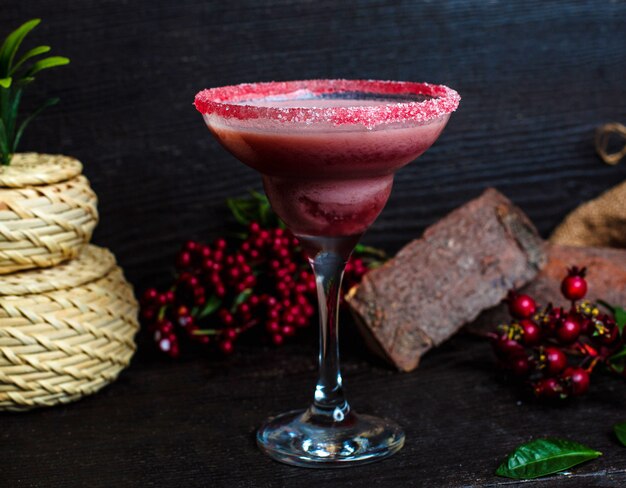 Ñ Ranberry Drink in einem mit rosa Sand bedeckten Glas