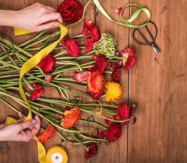 Ranunkulyus Strauß roter Blumen auf einem Holz