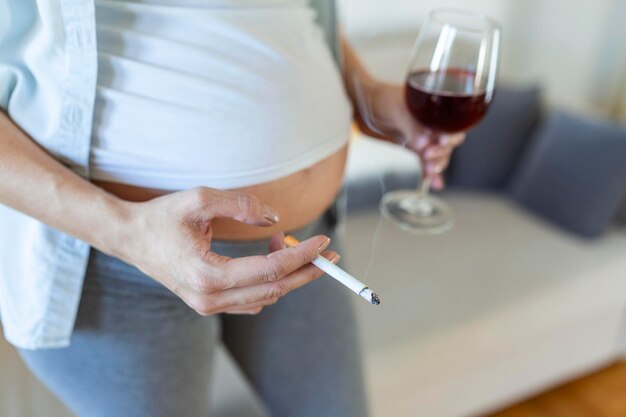 Rauchen und AlkoholschwangerschaftFrau in langer Schwangerschaft Alkoholkonsum und ZigarettenrauchenProbleme des Alkoholismus und der GeburtsdauerGefahr des Verlusts eines Babys Fehlgeburt Alkoholiker