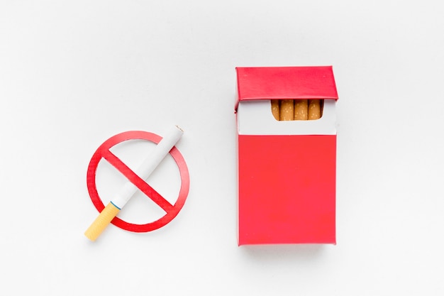 Raucherentwöhnungsschild neben Zigarettenschachtel