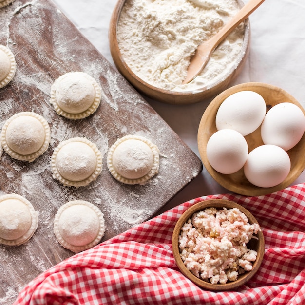 Kostenloses Foto ravioli auf holzbrett mit zutaten