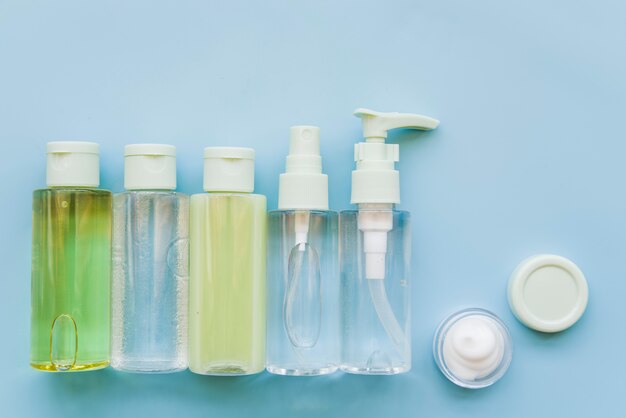 Realistische kosmetische Glasflasche kann Sprühbehälter und Feuchtigkeitscreme auf blauem Hintergrund