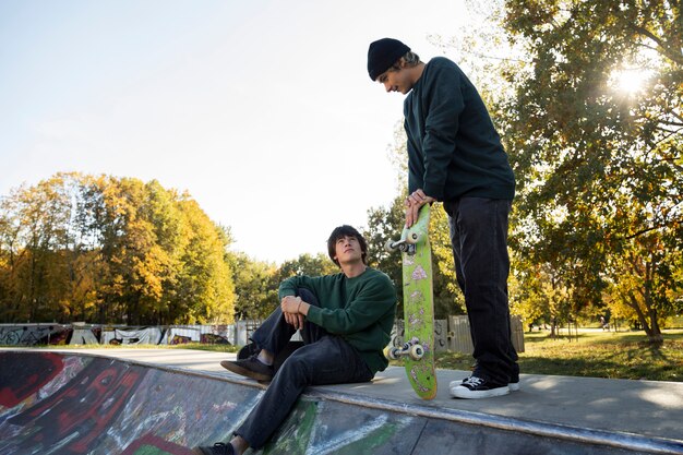 Rebellische Teenager in der Seitenansicht des Skateparks