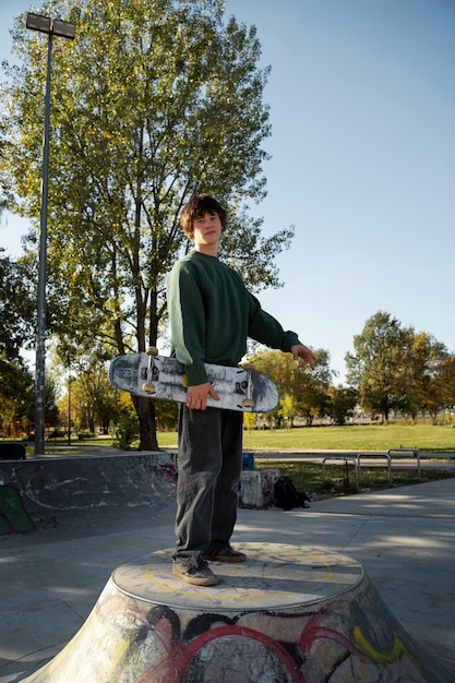 Kostenloses Foto rebellischer teenager in der seitenansicht des skateparks