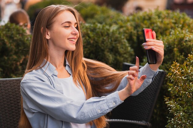 Recht blondes Mädchen, das selfies nimmt