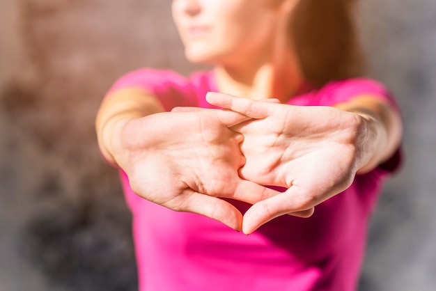 Recht sportliche junge Frau, die umklammerte Hände ausdehnt