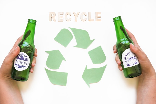 Kostenloses Foto recycle-schriftzug mit symbol und hände mit flaschen