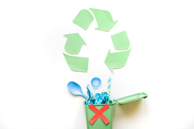 Recycling-Symbol und Mülleimer mit Plastikmüll