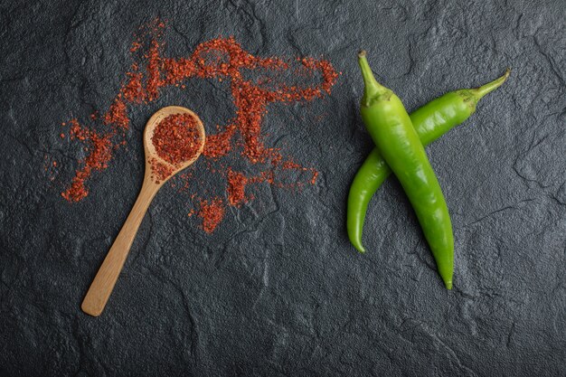 Red Hot Chili Pepper mit grünem frischem Pfeffer auf schwarzem Hintergrund.