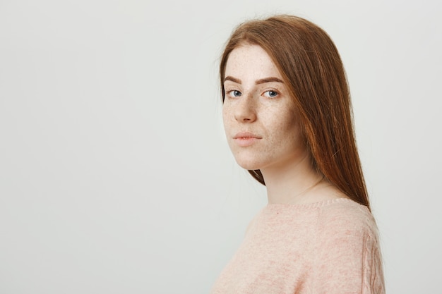 Redhead hübsches Mädchen drehen Gesicht in die Kamera und sehen ernst