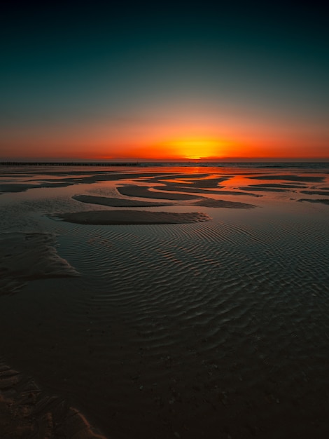 Reflexion des Sonnenuntergangs im Ozean gefangen in Domburg, Niederlande
