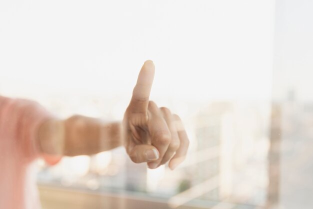 Reflexion des Zeigens des Fingers auf Fenster