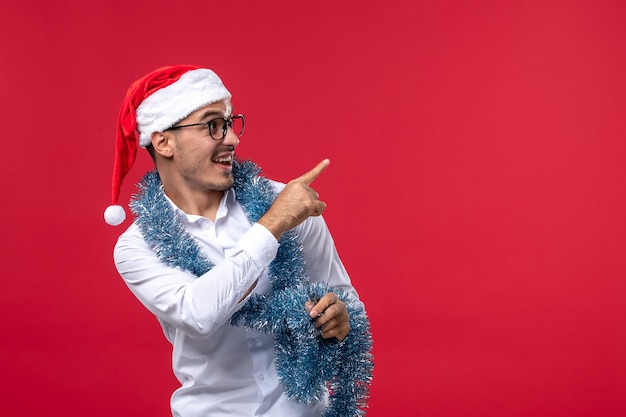 Kostenloses Foto regelmäßiger mann der vorderansicht, der neues jahr an den menschlichen feiertagsweihnachten der roten wand feiert