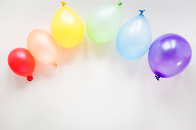 Kostenloses Foto regenbogen gemacht von den luftballonen auf tabelle