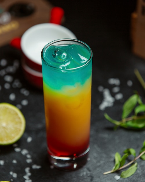 Regenbogencocktail mit Eis auf dem Tisch