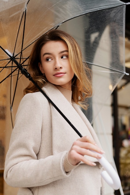 Regenporträt der jungen schönen Frau mit Regenschirm