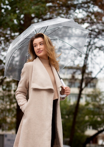 Regenporträt der jungen schönen Frau mit Regenschirm