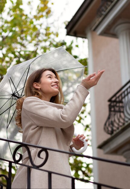 Regenporträt der jungen schönen Frau mit Regenschirm
