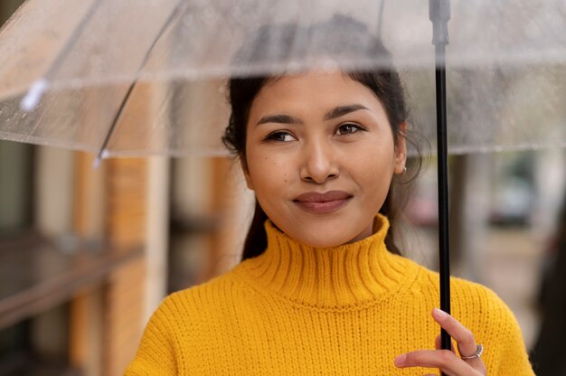 Regenporträt der jungen und schönen Frau mit Regenschirm