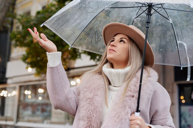 Regenporträt der jungen und schönen Frau mit Regenschirm