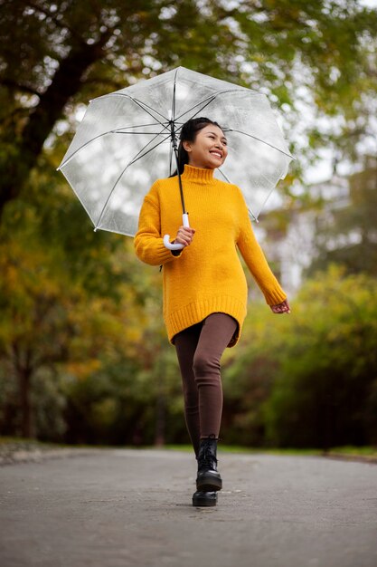 Regenporträt der jungen und schönen Frau mit Regenschirm