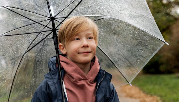 Regenporträt eines jungen und gutaussehenden Jungen