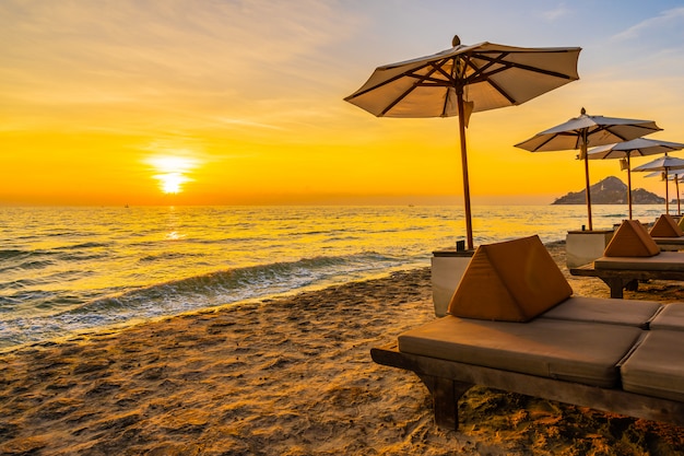 Kostenloses Foto regenschirm und stuhl mit kissen um schöne landschaft von strand und meer