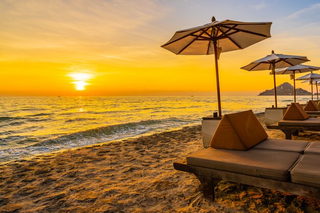 Regenschirm und Stuhl mit Kissen um schöne Landschaft von Strand und Meer