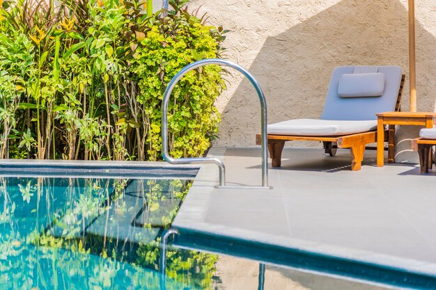 Regenschirm und Stuhl um Swimmingpool neary Seeozean setzen mit blauem Himmel und weißer Wolke auf den Strand