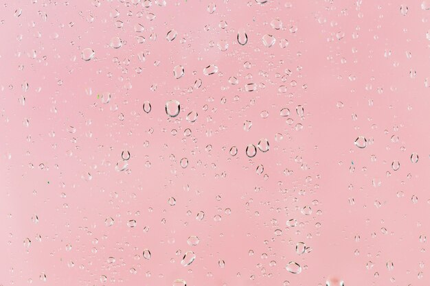 Regentropfen auf rosa Oberfläche