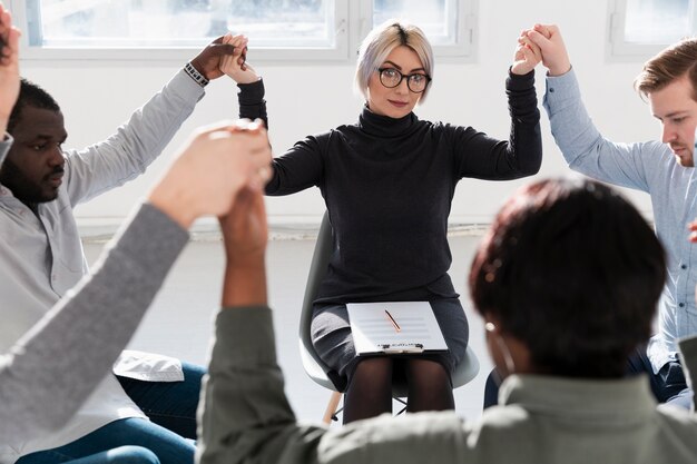 Rehabilitationsarzt, der Hände mit Patienten anhebt