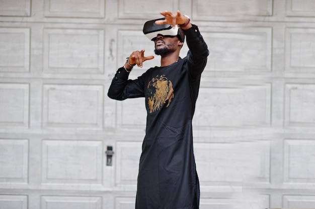 Reicher afrikanischer Mann in stilvoller traditioneller Kleidung in vr-Brille Konzept der Zukunft Afrikas