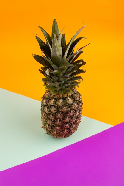 Reife Ananas reif weich auf einer lila seegrünen orange Zusammensetzung