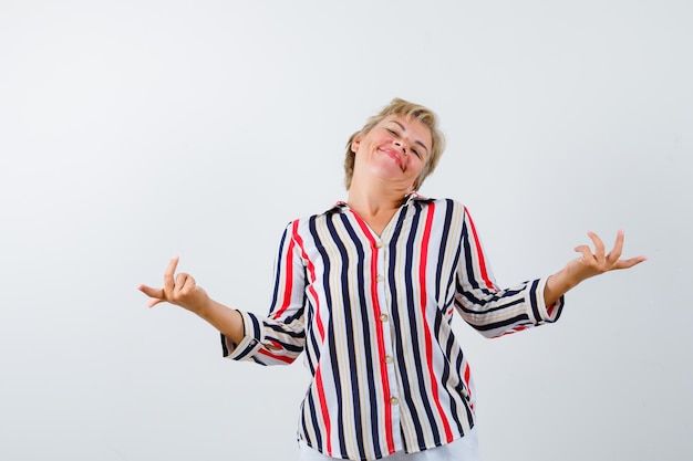 Reife blonde Frau in einem vertikal gestreiften Hemd