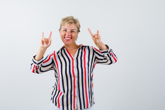 Reife blonde Frau in einem vertikal gestreiften Hemd