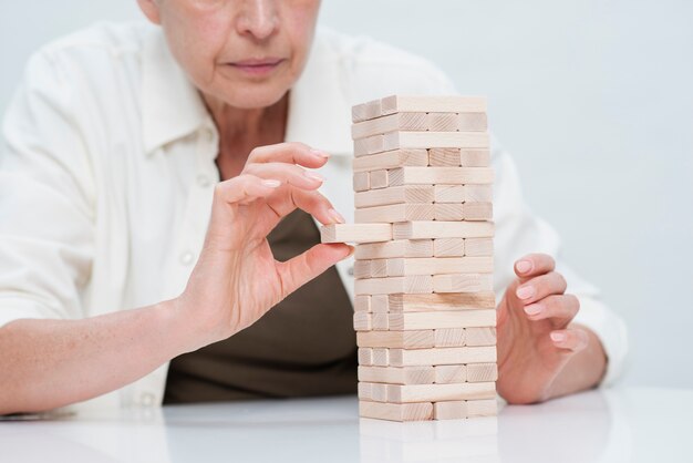 Reife Frau der Nahaufnahme, die jenga spielt