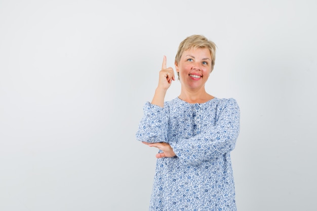 Reife Frau, die im Kleid zeigt und selbstbewusst aussieht.