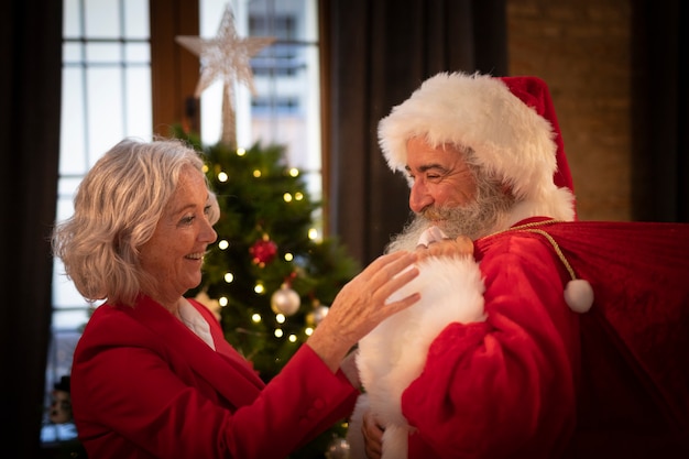 Kostenloses Foto reife frau, die weihnachtsmann gründet