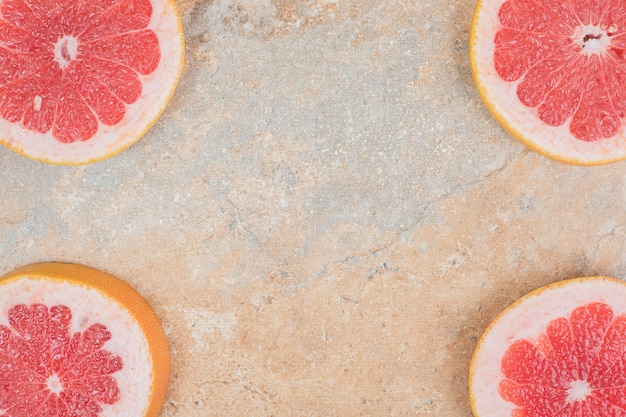 Reife Grapefruitscheiben auf Marmoroberfläche. Hochwertiges Foto